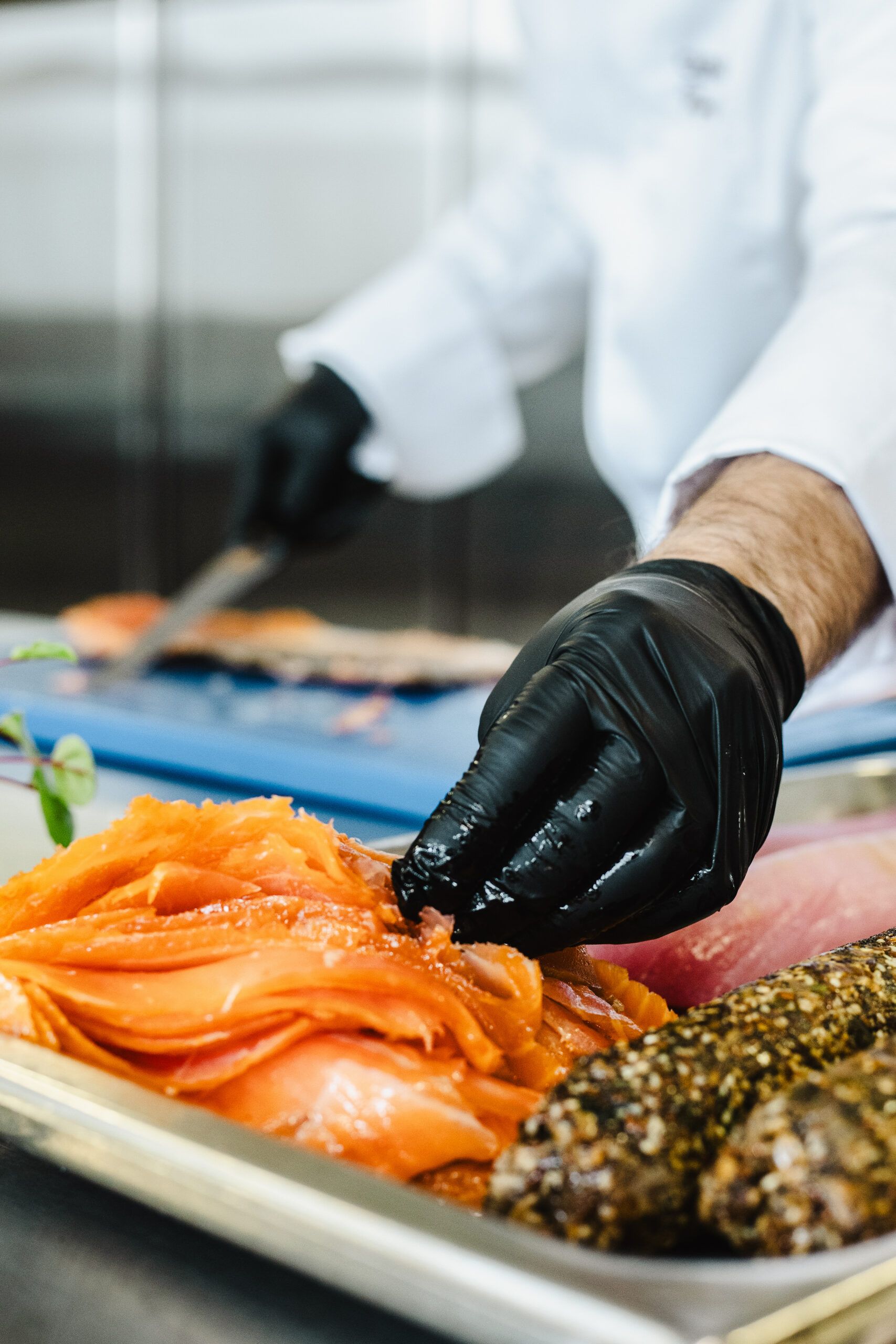 main qui prend du saumon pour le couper